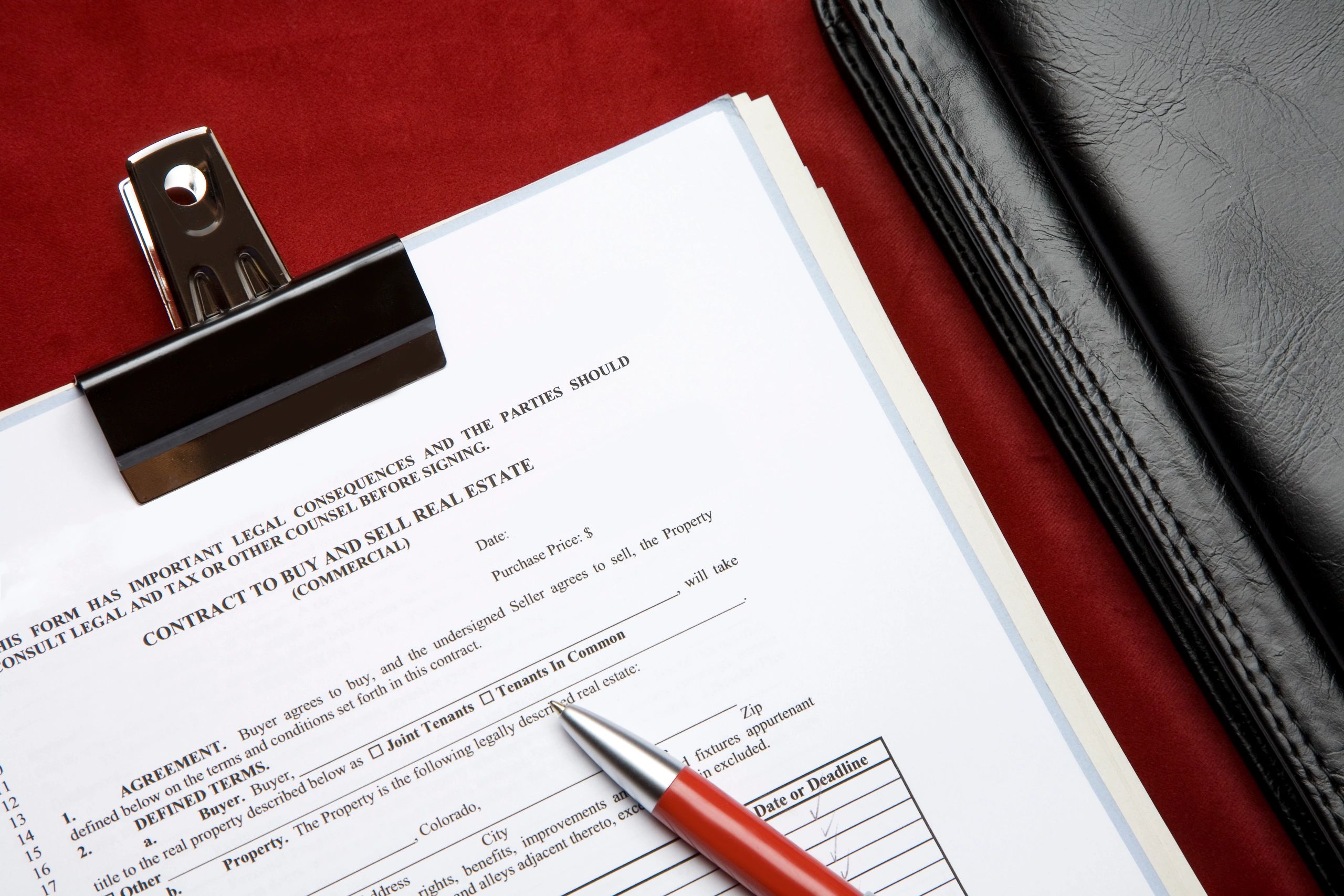 Real estate contract and pen on a desk