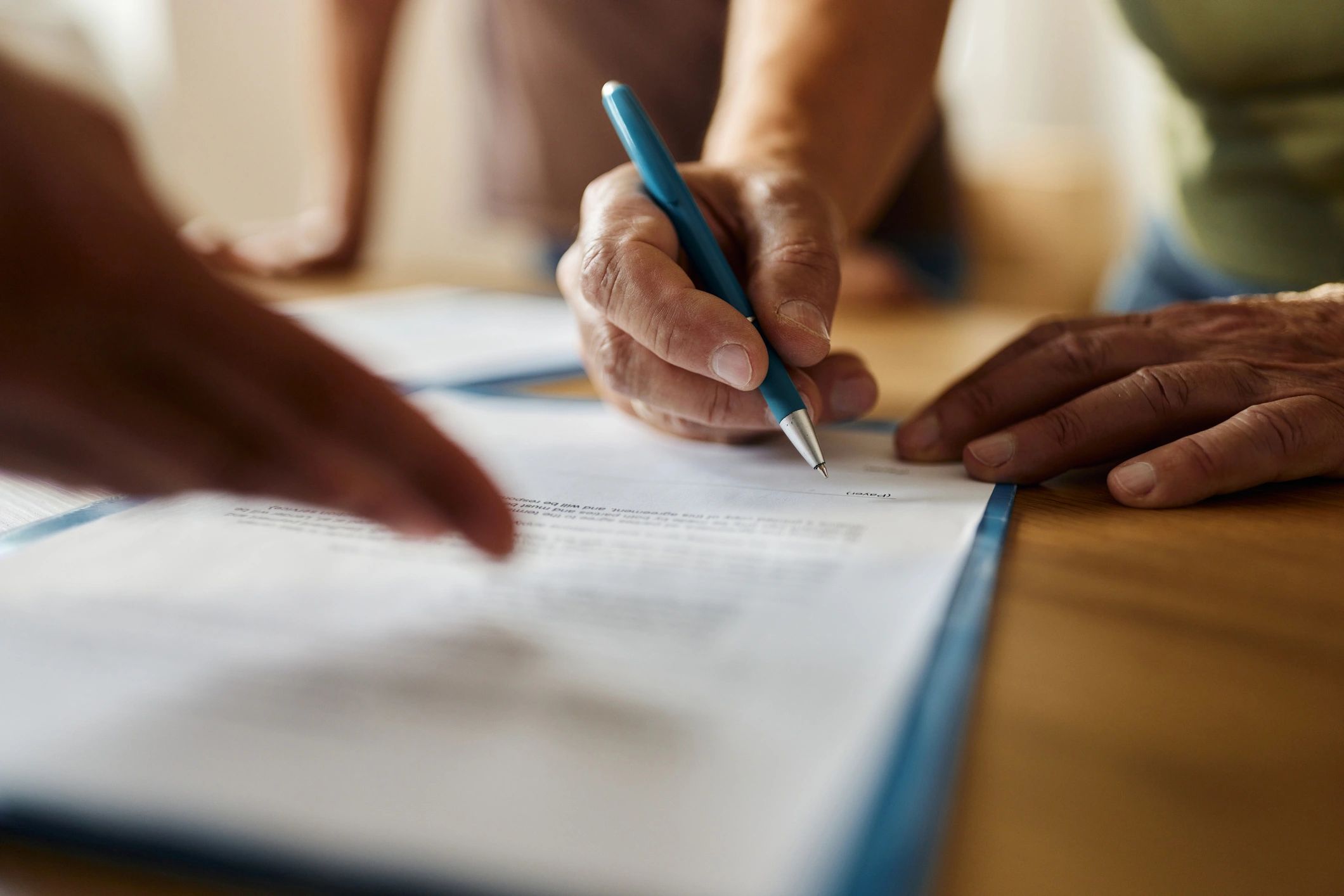 Close-up of a person signing a contract