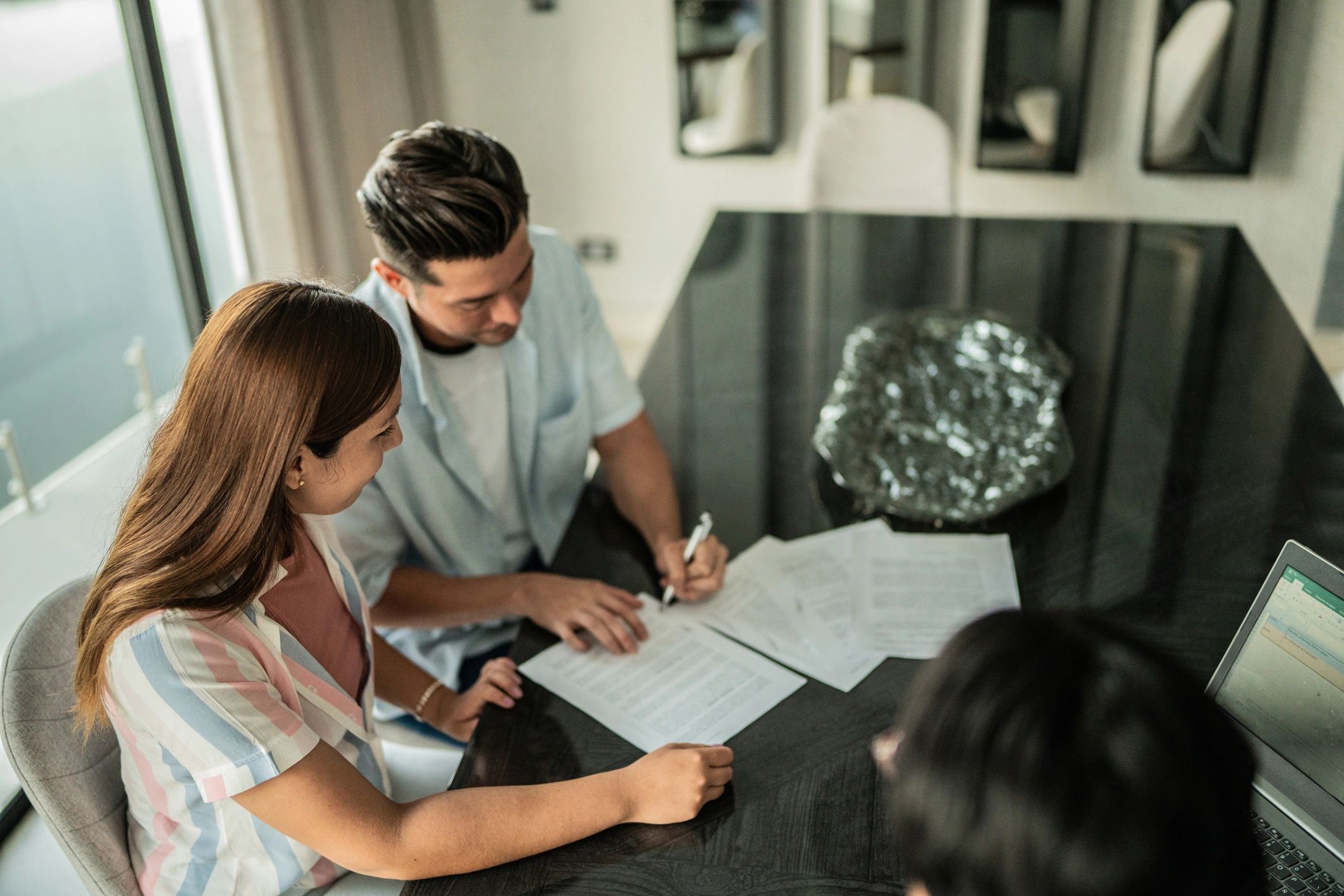 Couple signing documents at home