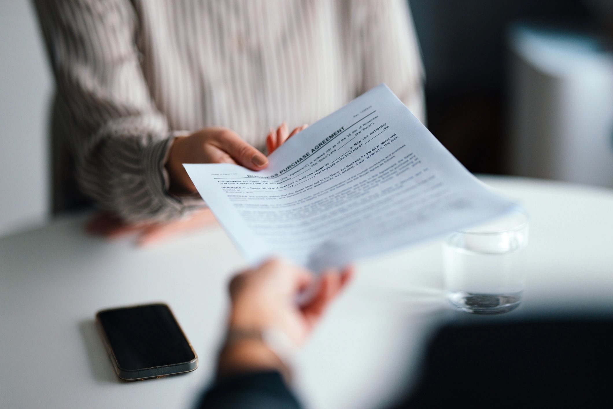 Professional handing over an official document during a business meeting