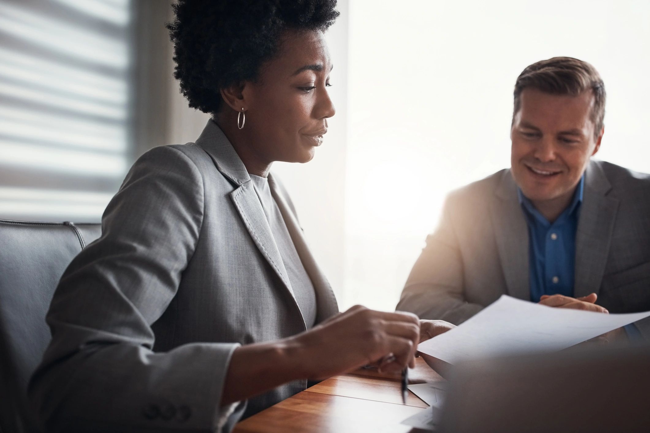 Two professionals reviewing closing paperwork at a desk